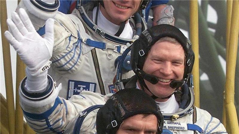 Der Kommandant der ersten Langzeitmission zur Internationalen Raumstation, der amerikanische Astronaut Bill Shepherd (M), und die russischen Kosmonauten Juri Gidsenko (unten) und Sergej Krikaljow (oben) winken, bevor sie auf dem Kosmodrom in das Raumschiff „Sojus-TM-31“ einsteigen. (Archivbild)