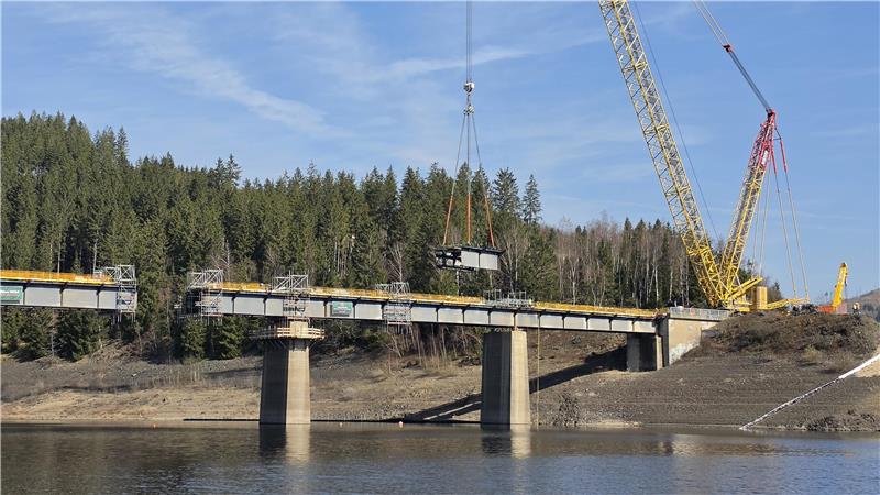 Ein Kran hebt das erste Teil der Bramkebrücke heraus.
