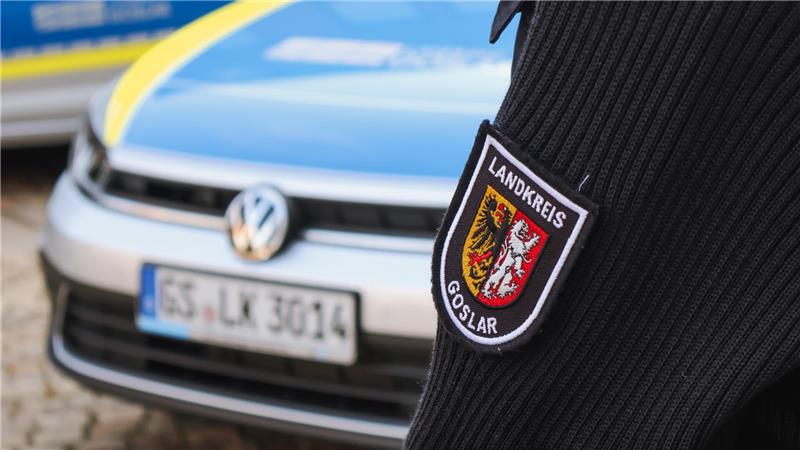 Ein Mitarbeiter des Landkreises Goslar steht vor einem Auto.