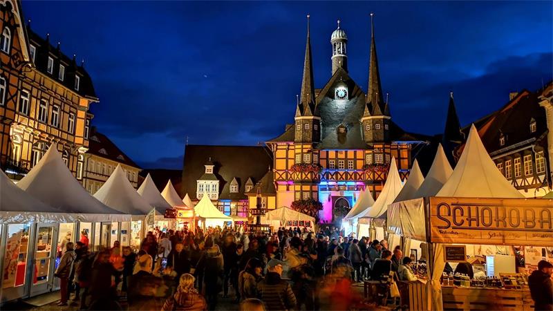 Das Foto zeigt einen Blick abends auf den Marktplatz von Wernigerode mit zahlreichen Ständen und vielen Menschen.