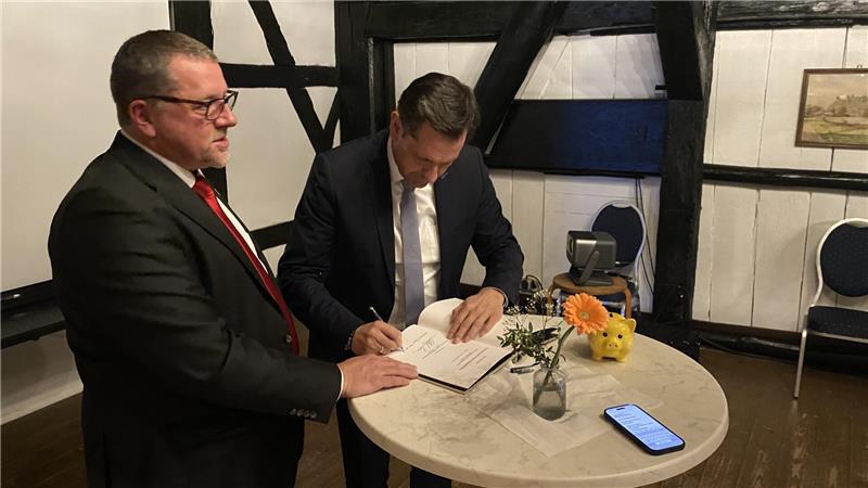 Olaf Lies trägt sich in das Goldene Buch der Gemeinde Liebenburg ein.