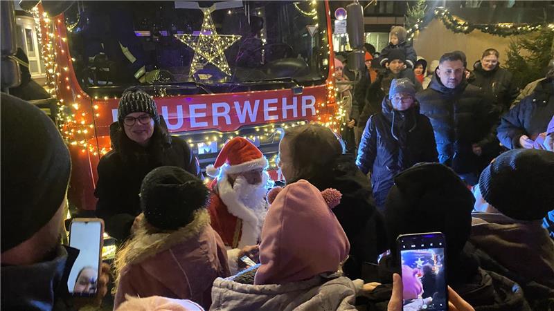 Glanzvoller Start: Eiskunstshow und Nikolaus ziehen die Massen an Der Nikolaus vor einem beleuchteten Feuerwehrauto verteilt Schokolade