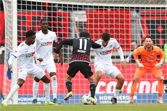Der Nürnberger Kanji Okunuki (M) kämpft mit Christian Conteh (l-r), Maxwell Gyamfi und Dave Gnaase von Osnabrück um den Ball.
