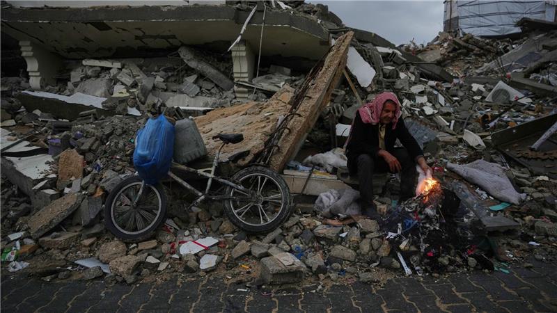 Der Palästinenser Mohammed al-Jabri, 58, wärmt sich neben einem Feuer, während er auf den Trümmern eines Gebäudes sitzt, das während der israelischen Luft- und Bodenoperationen im Viertel Sheikh Radwan zerstört wurden.