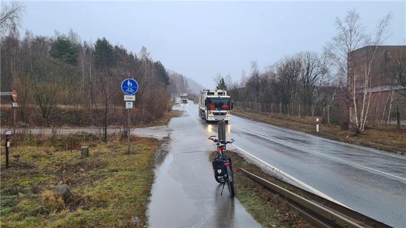 Ein Rad steht im Regen auf einem Radweg, der plötzlich endet.