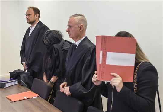 Der Rechtsanwalt Christian Beckmann (l-r), eine angeklagte Erzieherin, der Rechtsanwalt Andre Wallmüller und eine zweite angeklagte Erzieherin stehen im Sitzungssaal des Amtsgerichts.