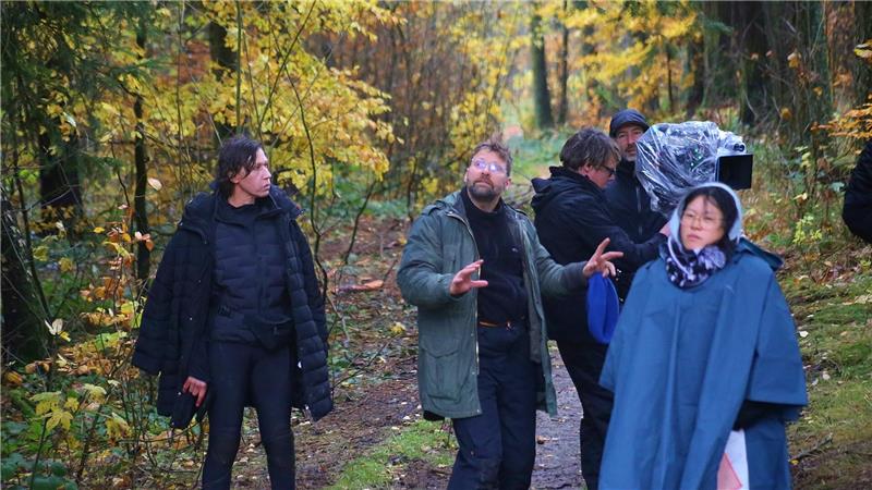 Das Foto zeigt eine Gruppe von Menschen, die im strömenden Regen stehen.