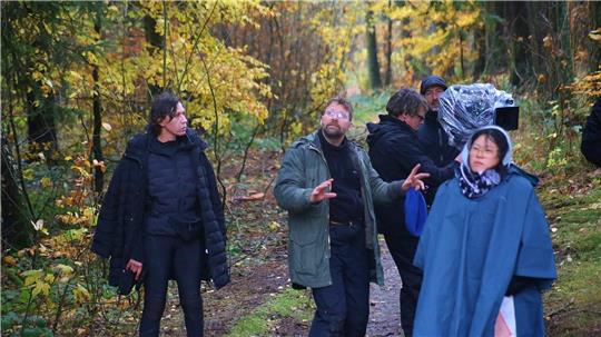 Das Foto zeigt eine Gruppe von Menschen, die im strömenden Regen stehen.