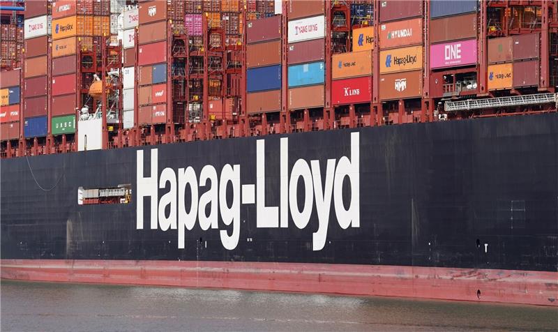 Der Schriftzug von Hapag-Lloyd ist an einem Containerschiff angebracht.