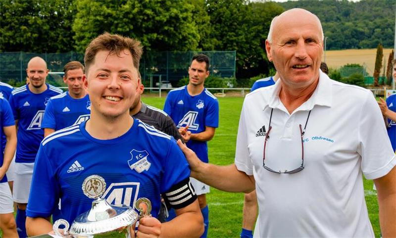Der Sieger des 51. Bärenkopfpokals heißt FC Othfresen. FCO-Vorsitzender Wolfgang Fricke überreicht den Pokal an Kapitän Henrik Melzian. Foto: Drechsler