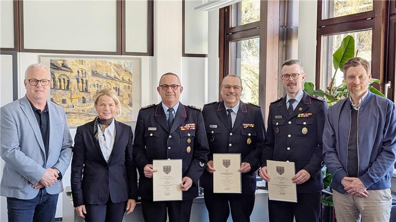 Der Stadtbrandmeister Christian Hellmeier (3. v. li.) mit seinem ehemaligen und künftigen Stellvertreter: Kevin Schmidt (2. v. re.) löst Frank Slotta (3. v. re.) ab. Oberbürgermeisterin Urte Schwerdtner hat im Beisein von Tim Meißner (li.) und Sven Busse (re.) die Urkunden übergeben.