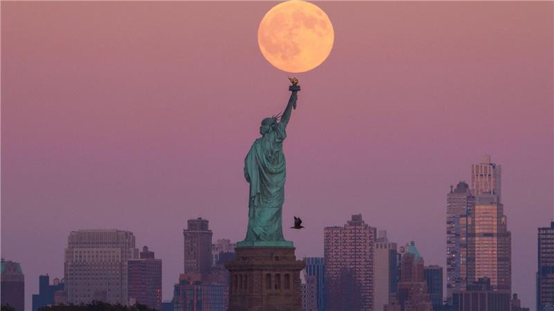 Bilder des Tages Der Supermond geht hinter der Freiheitsstatue in New York auf.