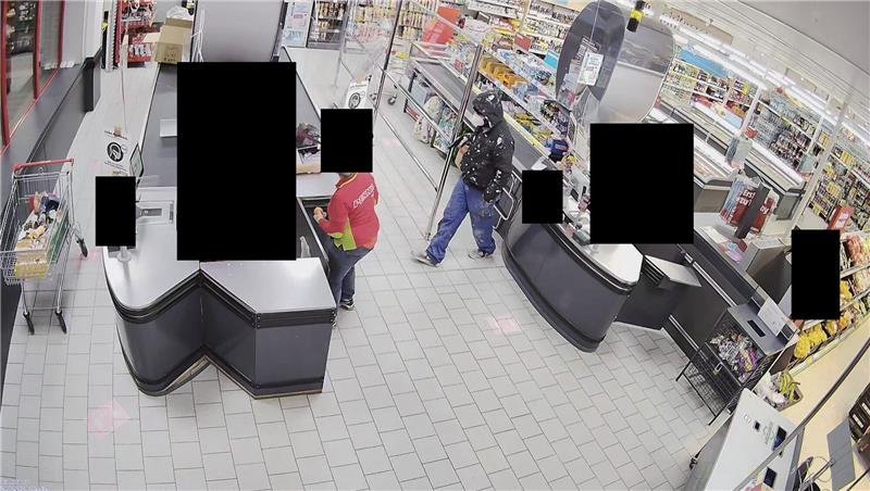 Nach Überfall auf Penny: Polizei sucht mit Fotos nach dem Täter Der Täter geht auf die Kasse zu. Foto: Polizei