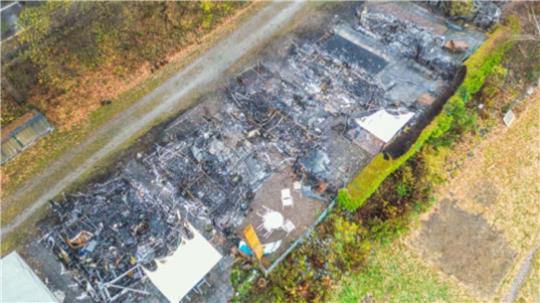 Eine Aufnahme mit einer Drohne zeigt die Trümmer, die noch auf den vom Feuer verwüsteten Parzellen liegen.