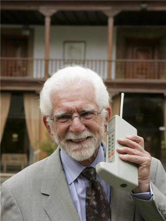 Der US-Ingenieur Martin Cooper hält eines der ersten Mobiltelefone.