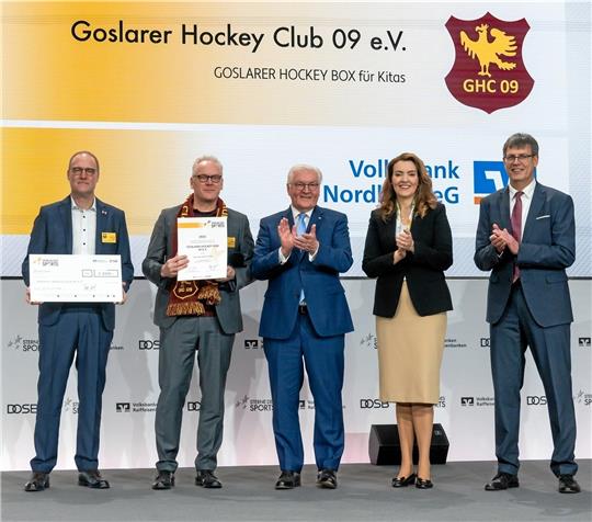 Der Vorsitzende des Goslarer HC 09, Volker Barckmann (2. v.li.), mit der Auszeichnung. Bundespräsident Frank-Walter Steinmeier (3.v.re.), Marija Kolak, Präsidentin des Bundesverbandes der Deutschen Volksbanken und Raiffeisenbanken, und DOSB-Präsident Thomas Weikert applaudieren. Markus Creydt, Vorstand der Volksbank Nordharz, hat den Scheck über das Preisgeld von 1000 Euro in der Hand. Fotos: Gerald Matzka/DOSB/BVR