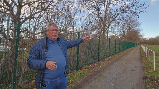 Der Vorsitzende des Goslarer SC 08, Burkhard Siebert, deutet auf den ersten Zaunabschnitt, den die Stadt zum Schutz vor Wildschweinen errichtet hat.