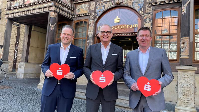 Der Vorstand der Sparkasse Hildesheim-Goslar-Peine legt die Bilanz für 2024 vor: (.l.) Ingmar Müller, Jürgen Twardzik und Steffen Lange mit symbolischem Herz für die Region.