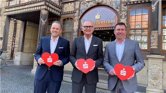 Der Vorstand der Sparkasse Hildesheim-Goslar-Peine legt die Bilanz für 2024 vor: (.l.) Ingmar Müller, Jürgen Twardzik und Steffen Lange mit symbolischem Herz für die Region.