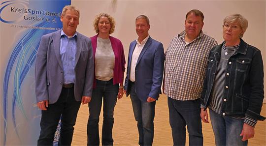 Fünf Personen stehen nebeneinander vor einem Banner mit dem Schriftzug 'Kreissportbund Goslar e.V.'