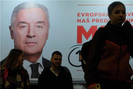 Der Wahlkampf ist zu Ende: Menschen gehen an einem Plakat des pro-westlichen Amtsinhabers Milo Djukanovic vorbei.