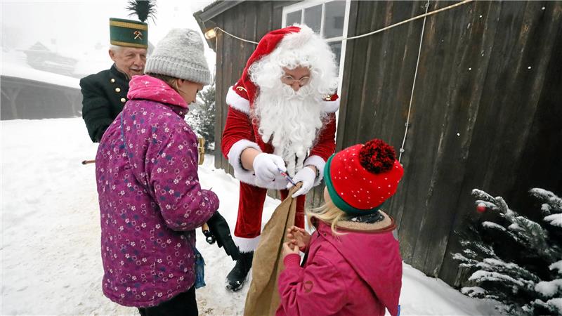 Der Weihnachtsmann verteilt kleine Geschenke im Oberharzer Bergwerksmuseum an Kinder.