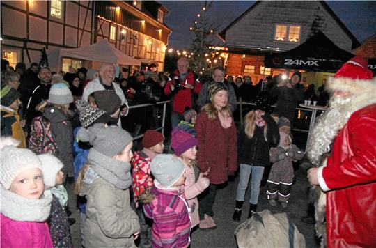 Der Weihnachtsmann übergibt an die Kinder, nach dem Aufsagen von Gedichten und Liedtexten, Geschenke und sorgt für strahlende Gesichter.  Foto: Hohaus
