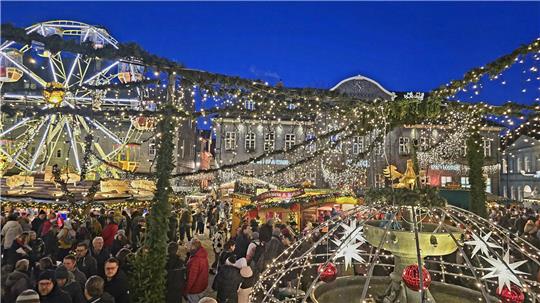 Der Weihnachtsmarkt in Goslar. Zu sehen sind ein Riesenrad, viele Menschen und jede Menge Lichterketten.