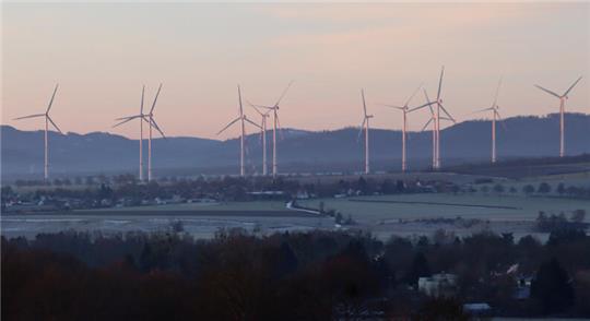 Windräder drehen sich vorm Harz als Kulisse.