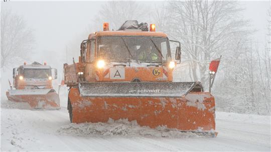 Schneepflüge sind auf verschneiten Straßen unterwegs. Auch der Winterdienst schlägt sich in den Kosten für die Straßenreinigungsgebühr nieder.