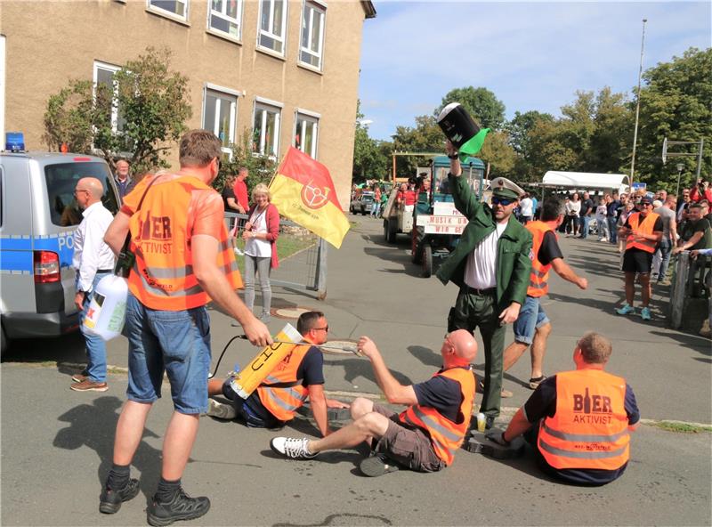 Der Zug durch die Gemeinde kam kurzzeitig zum Stehen. Denn die Bieraktivisten hatten sich auf der Straße festgeklebt. Woraus der Spezialkleber bestand, blieb offen. Foto: Leifeld