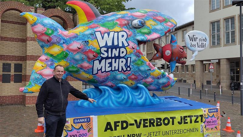Bunter Fisch auf Berlinreise: Bündnis wirbt für AfD-Verbot Der bekannte Düsseldorfer Wagenbauer Jacques Tilly vor seinem Fisch. Er unterstützt damit die Forderung nach einem AfD-Verbot. (Handout-Bild)