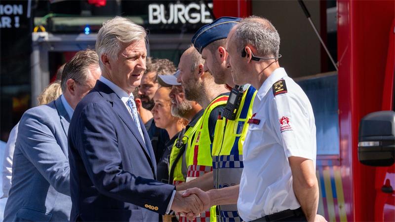 Der belgische König Philippe (vorne) und Ministerpräsident Bart De Wever bedanken sich bei Rettungskräften. 