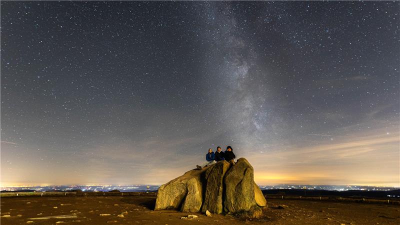 Nachtaufnahme des Brockenfelsens, bei dem die Milchstraße zu sehen ist.