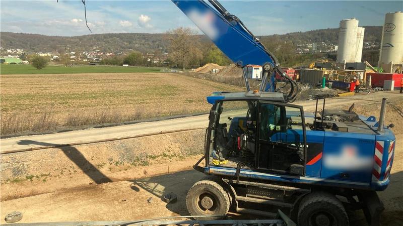ICE fährt gegen Baggerarm - Baggerfahrer verletzt Der beschädigte Bagger steht an einer Baustelle neben den Bahngleisen.