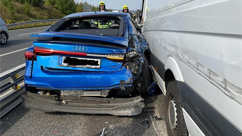 Der blaue Audi klemmt zwischen dem Sprinter und einer Schutzplanke fest.
