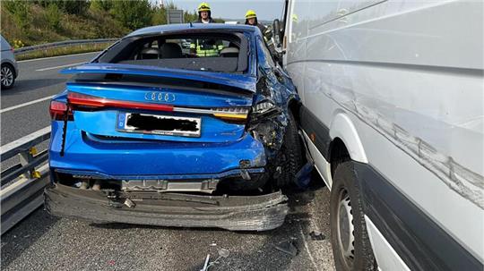 Der blaue Audi klemmt zwischen dem Sprinter und einer Schutzplanke fest.