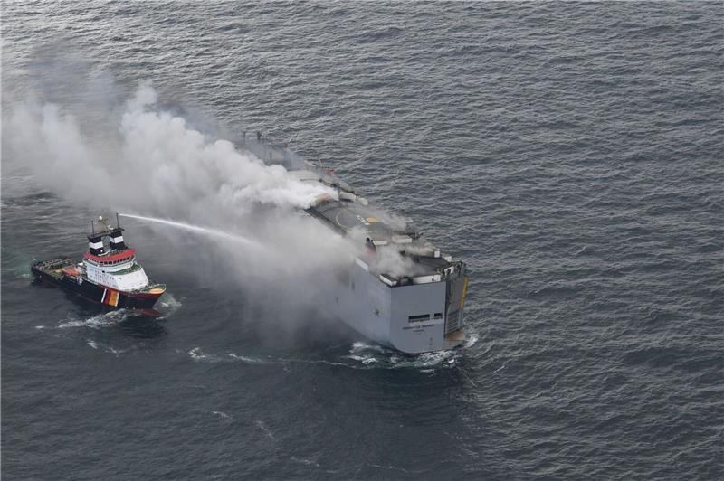 Küstenwache: Brand auf Autofrachter kleiner geworden Der brennende Frachter «Fremantle Highway» in der Nordsee. Links im Bild ist der deutsche Notschlepper «Nordic» zu sehen, der das Feuer auf dem Frachter bekämpft.