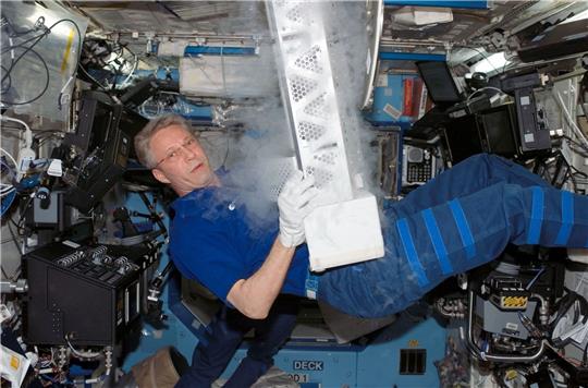 Der deutsche Astronaut Thomas Reiter an Bord der Internationalen Raumstation ISS: Hier hantiert er mit Teilen einer Laborgefriereinrichtung.