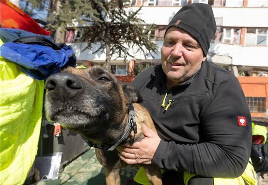 Der deutsche Rettungshundeführer Uwe Elze mit seiner Hündin Pia am Rande eines Trümmerfeldes in Kahramanmaras.