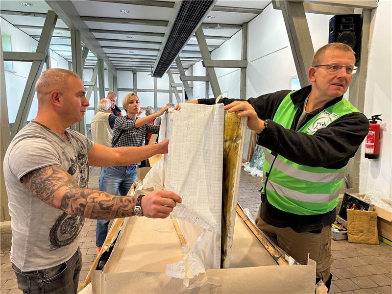 Der ehemalige Chef des Bergstadtvereins, Olaf Frank (rechts) packt das Bild zusammen mit Tatjana Turoua und Dimitry Priknodorsky in der Rathausscheune aus. Foto: Eggers