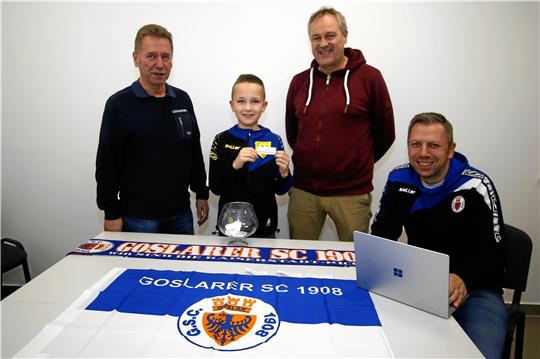 Der elfjährige Ilay zieht unter Aufsicht des GSC-Vorsitzenden, Werner Penndorf (li.), und des Abteilungsleiters Fußball, Jens Bastam (2. v. re.), die Gruppen. Björn Vorlop, 2. Vorsitzender des GSC, hält das Ergebnis gleich digital fest. Foto: Epping