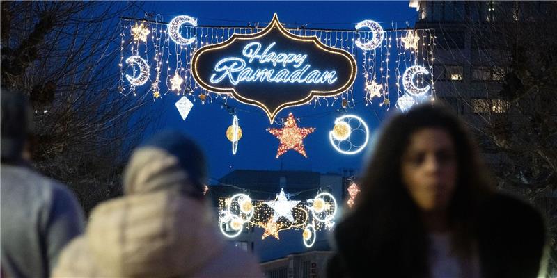 Der erleuchtete Schriftzug «Happy Ramadan» ist bei Einbruch der Dunkelheit auf der Fressgass in Frankfurt am Main zu sehen.