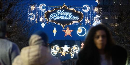 Der erleuchtete Schriftzug «Happy Ramadan» ist bei Einbruch der Dunkelheit auf der Fressgass in Frankfurt am Main zu sehen.