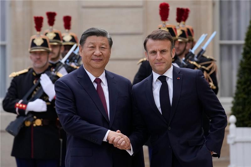 Der französische Präsident Emmanuel Macron (r) begrüßt Chinas Präsident Xi Jinping vor ihrem Treffen im Elysee-Palast.