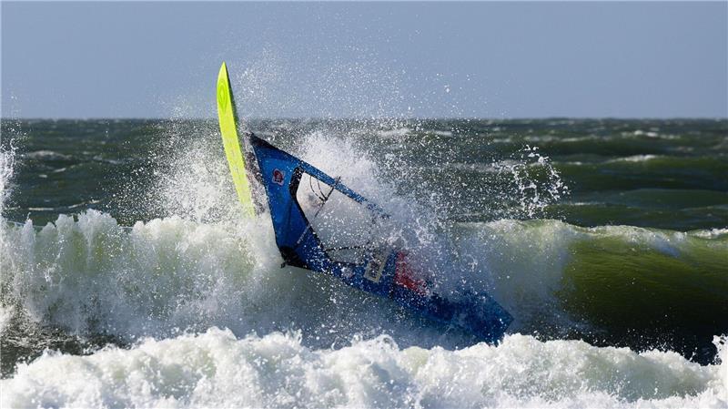 Der französische Windsurfer Antoine Martin stürzt nach einem Sprung im Shorebreak während des Windsurf World Cups auf Sylt.