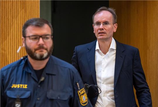 Der früheren Wirecard-Vorstandschef Markus Braun (r) wird von einem Justizbeamten in den Gerichtssaal begleitet (Archivbild).