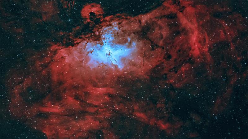 Roter Nebel mit hellem, blau leuchtendem Zentrum im Weltraum