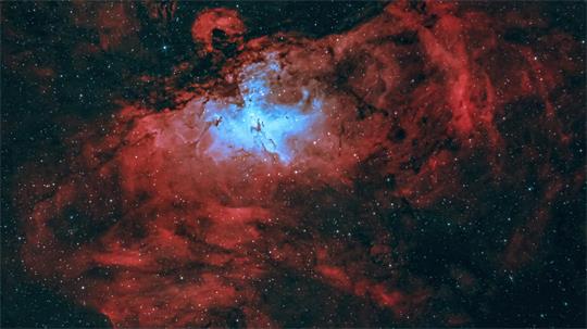 Roter Nebel mit hellem, blau leuchtendem Zentrum im Weltraum