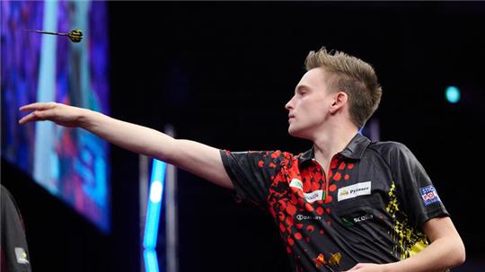 Der Dartprofi Ricardo Pietreczko wirft einen Pfeil in Richtung Scheibe.